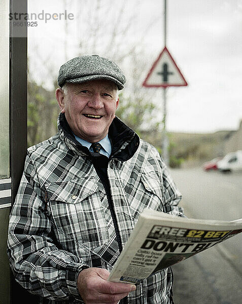 Einheimischer schottischer Mann steht mit Zeitung am Straßenrand  Bettyhill  Farr  Schottland  Großbritannien