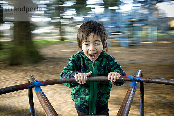 Ein kleiner Junge schreit vor Aufregung auf einem Karussell.