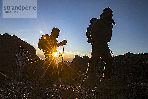 Silhouette von Bergsteigern bei Sonnenaufgang in der Nähe von Stella Point am Kilimandscharo  Tansania