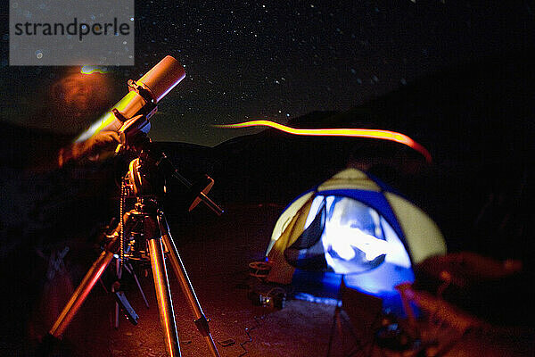 Ein Mann justiert sein Teleskop in der Nähe seines Zeltes in den White Hills in Kalifornien.