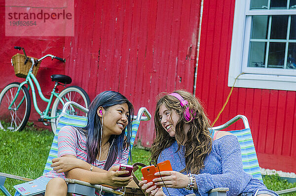 Teenager-Mädchen telefonieren gemeinsam und haben Spaß