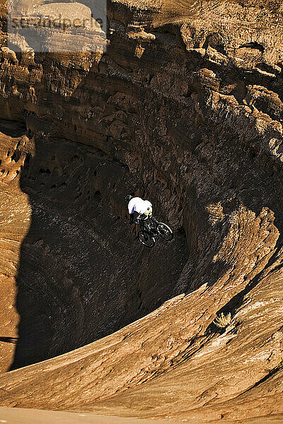 Mann fährt mit dem Mountainbike einen steilen Felsen hinunter in Moab  Utah.