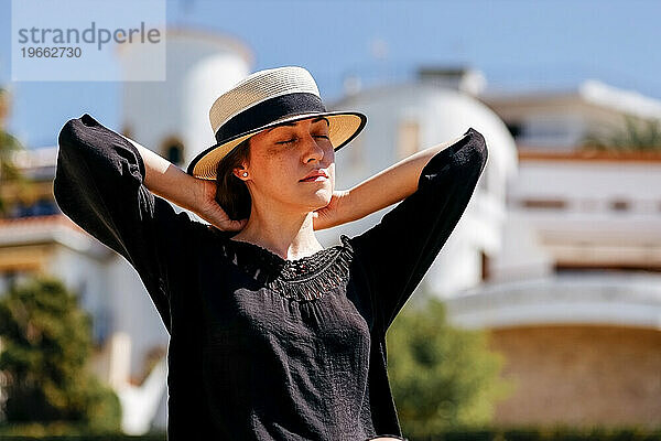 Porträt einer ruhigen Frau mit Hut an einem Sommertag.