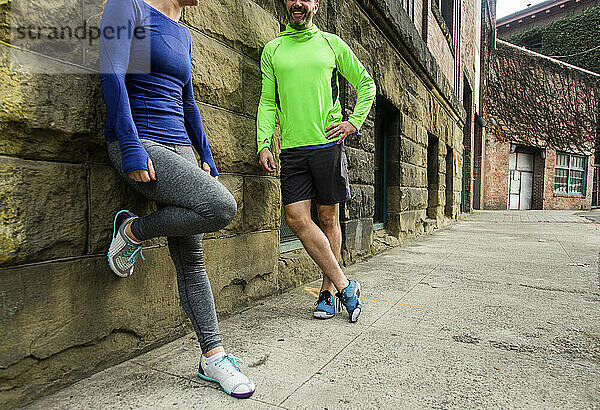 Männliche und weibliche Läufer unterhalten sich beim Ausruhen beim Joggen  Seattle  Washington State  USA