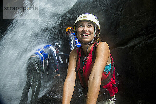 Eine Frau genießt mit anderen Touristen ein Wasserfallabenteuer in Puerto Rico.