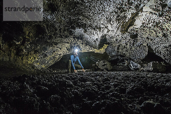 Eine junge Frau erkundet eine Vulkanhöhle im Lava Beds National Monument