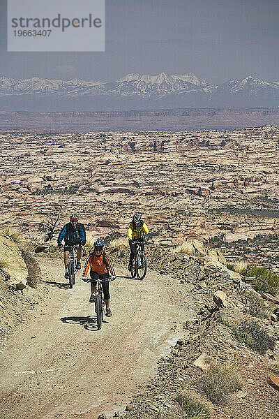 Drei Personen beim Mountainbiken auf einer unbefestigten Straße in der Nähe des Canyonlands National Park  Utah