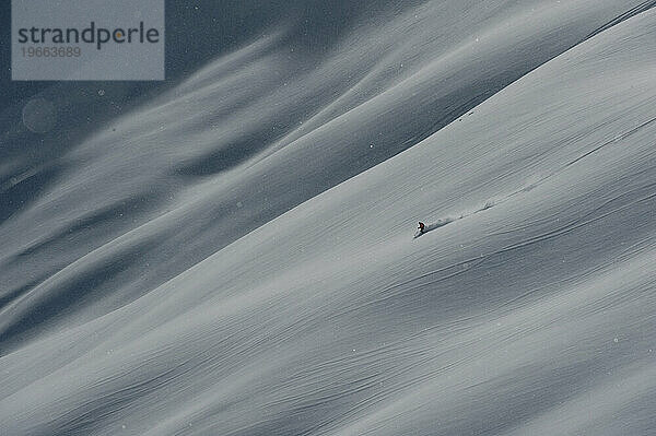 Ein einsamer Skifahrer steigt einen Gletscher hinab.