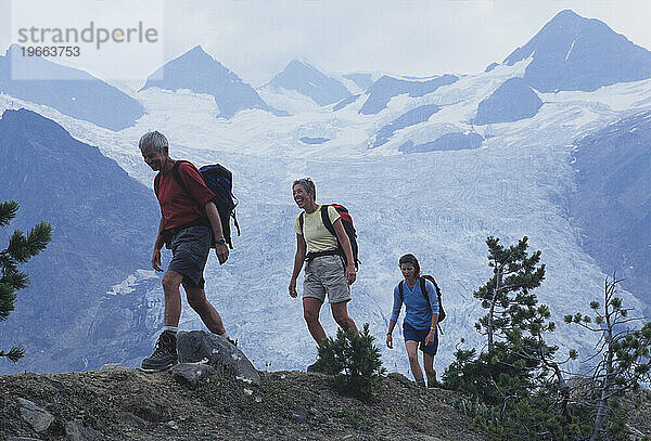 Drei Menschen wandern in der Nähe eines Gletschers in British Columbia  Kanada.