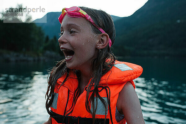 Mädchen lacht nach dem Schwimmen in einem norwegischen Fjord