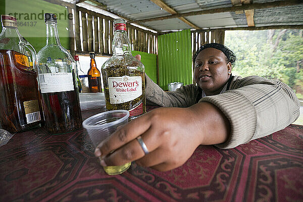 Eine Dominikanerin serviert einen Schuss lokalen „Bush Rum“ (dominikanischen Mondschein) mit frischem lokalem Anis. Wir haben herausgefunden  dass mit diesem Zeug nicht zu spaßen ist.