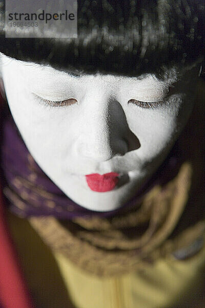 Porträt einer Geisha bei Nacht  nur mit dem Kopf  Draufsicht  Nahaufnahme  Blick nach unten.