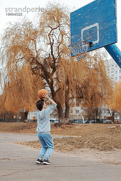 Ein junger Mensch spielt Basketball.