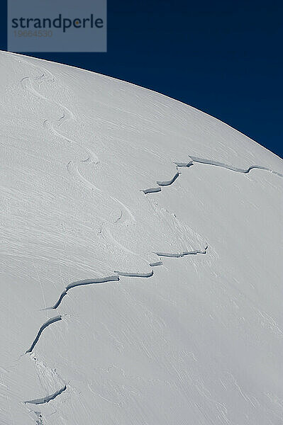 Skispuren führen in eine Schneebrettlawine.