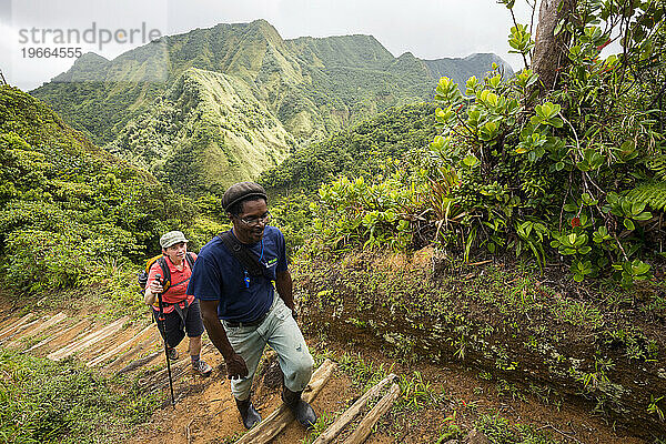 Eine Frau und ihr Führer wandern auf dem Weg zum Boiling Lake im Nationalpark Morne Trois Pitons auf der Karibikinsel Dominica.