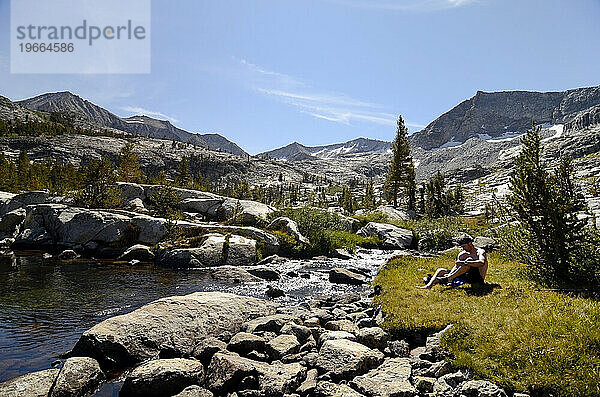 Ein Mann entspannt und reinigt sich an einem unberührten Wasserbecken an der Sierra High Route im Kings Canyon National Park  Kalifornien.