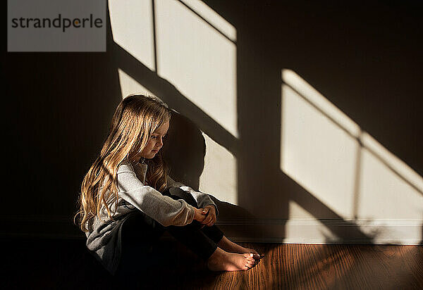 Junges Mädchen sitzt ruhig im schönen Licht