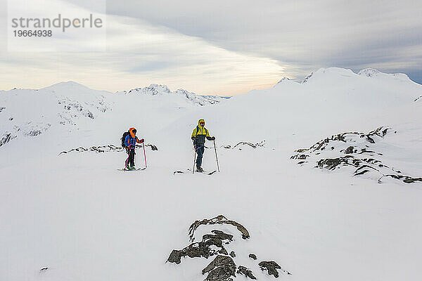 Zwei Freunde gehen Skitouren in rauem Berggelände