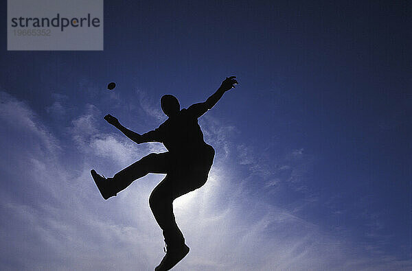 Eine Silhouette eines Mannes  der Hacky Sack spielt  Ottawa  Ontario  Kanada.