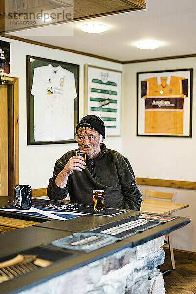 Älterer Mann genießt Bier neben der Theke in einem Pub  Schottland  Großbritannien