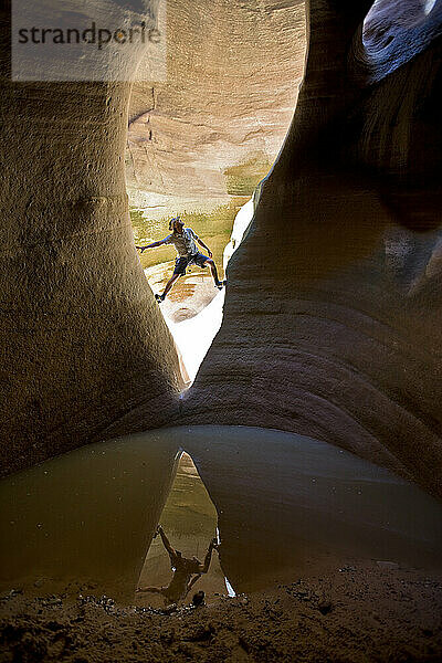 Mann stapft zwischen zwei Wänden in der Schlucht über dem Pool  Zion-Nationalpark  Utah.