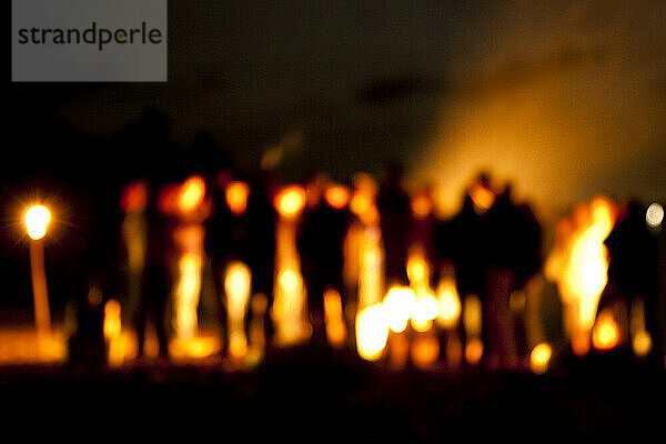 Eine Gruppe versammelte sich um ein Lagerfeuer am Ufer des Sebago-Sees.