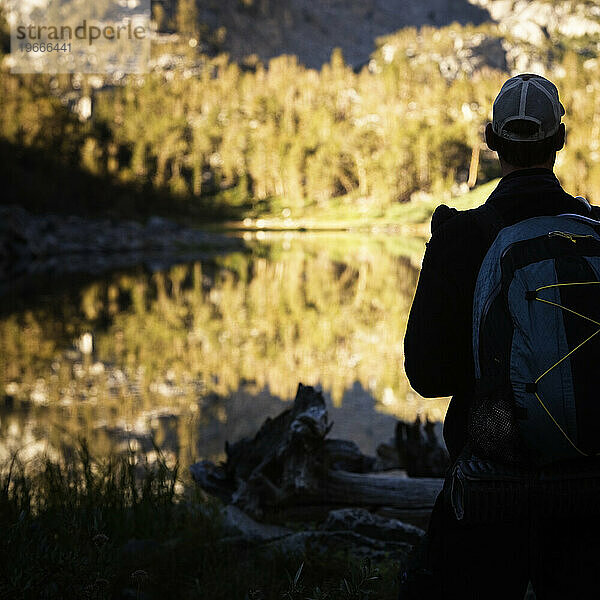 Backpacker-Silhouette vor einem Bergsee.