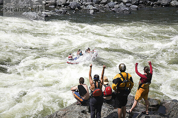 Eine Gruppe Paddler gratuliert einer anderen Gruppe  nachdem sie erfolgreich Stromschnellen auf dem Snake River bewältigt haben.