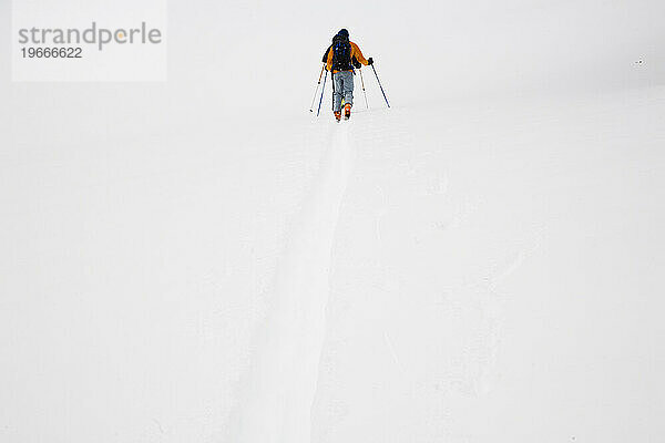 Ein Skifahrer folgt einer Spur im Hinterland.