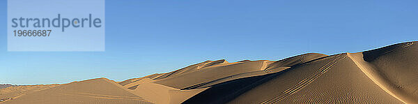 Horizontales Panorama Wüstensanddünen und blauer Himmel