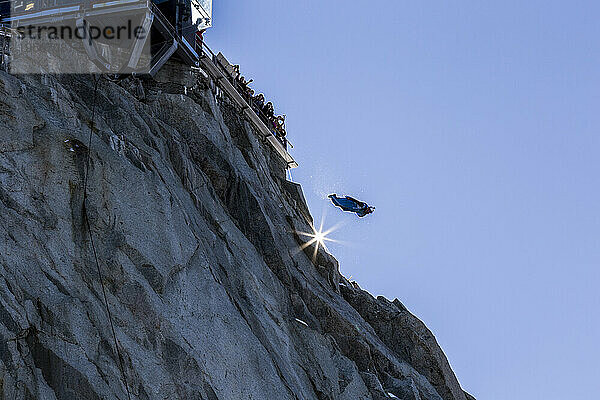 Wingsuit-Jumper springt unter jubelnder Menge vom Berggipfel