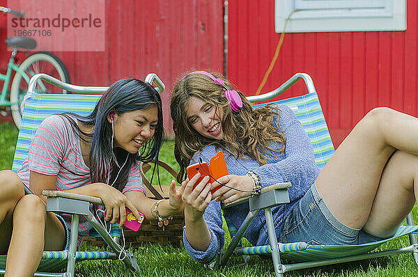 Teenager-Mädchen telefonieren gemeinsam und haben Spaß