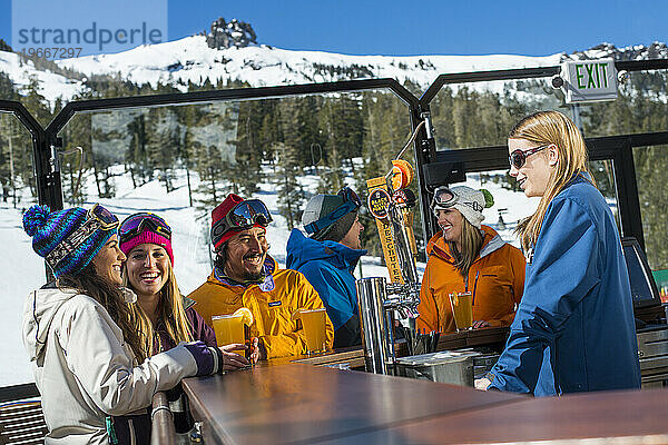 Eine Gruppe von Freunden genießt beim Après-Ski im Winter in Kirkwood  Kalifornien  eine Runde Bier in der Umbrella Bar im Kirkwood Mountain Resort.