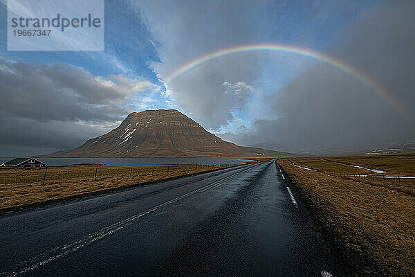 Ein Regenbogen erstreckt sich über eine isländische Szene
