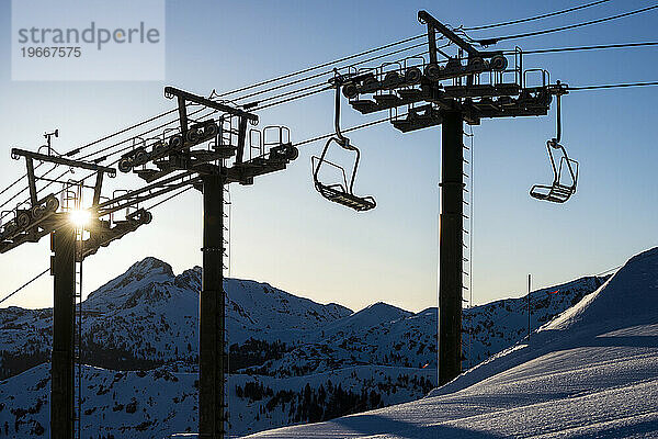 Der Sonnenaufgang zeichnet die Silhouette eines Sessellifts (Stuhl 6  Cornice Express) im Kirkwood Mountain Resort im Winter in Kirkwood  Kalifornien  auf.