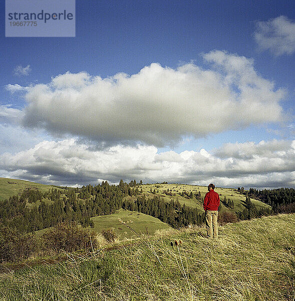 Eine Szene  in der ein Mann steht und die sanften Hügel in Oregon überblickt.