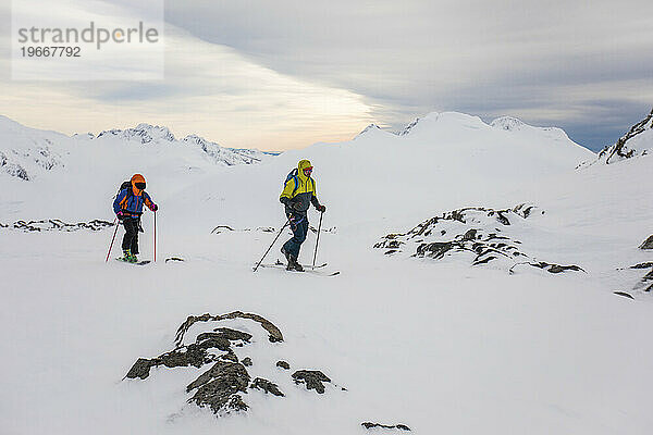 Vorderansicht von zwei Männern auf Skiern mit Blick auf die Berge