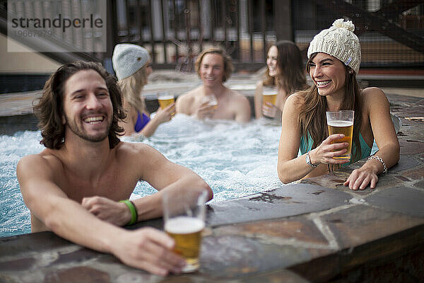 Gruppe von Freunden in einem Whirlpool im Winter.