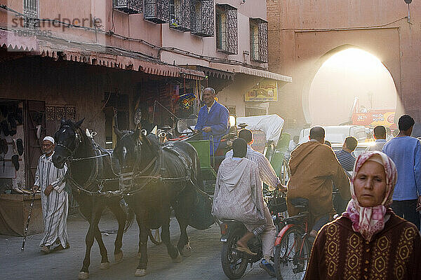 Menschen und Pferdewagen in einer Straße in der Medina (Altstadt). Marrakesch  Marokko.