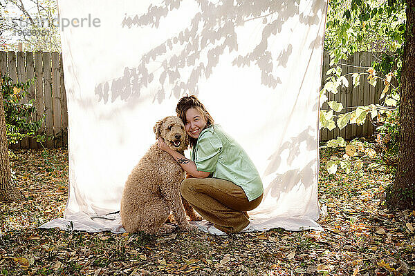 Woman sharing a hug with her golden doodle