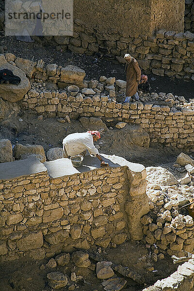 Arbeiter bauen Steinmauern im verlassenen Berber-Bergdorf Chenini wieder auf.
