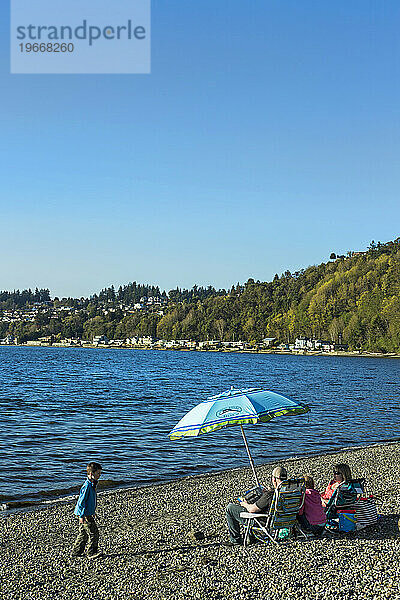 Familie mit zwei Kindern entspannt gemeinsam am Küstenstrand  Seattle  Washington  USA