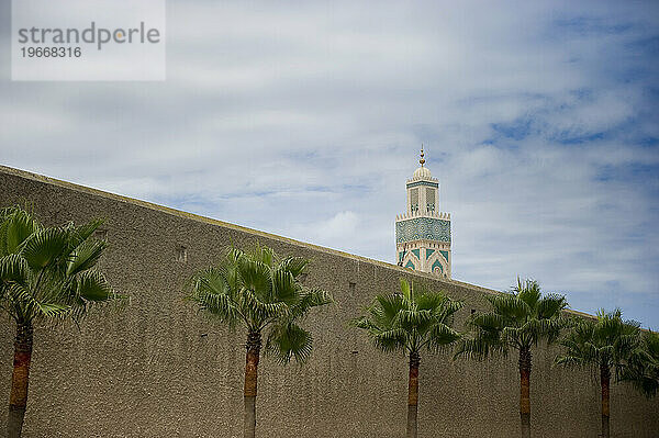 Der Turm einer Moschee blickt über die Stützmauer von Casablanca  Marokko.