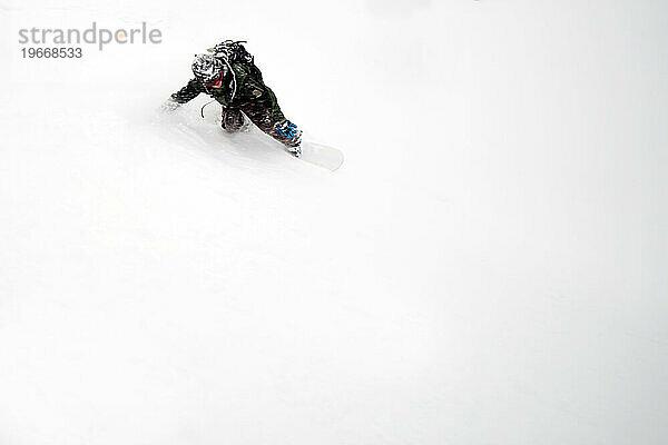 Ein Snowboarder fährt an einem Tag im frischen Pulverschnee.