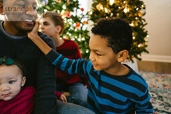 Schwarzer Vater mit Kindern  die zu Weihnachten glücklich und lächelnd sind