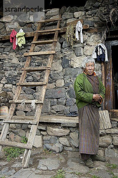 Frau vor ihrem Haus in Lingshi  Bhutan.