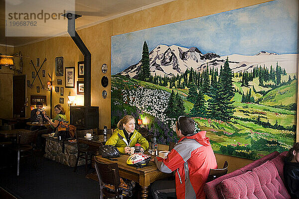 Ein abenteuerlustiges Paar genießt Kaffee unter einem Gemälde von Mt. Rainer  Seattle  Washington.