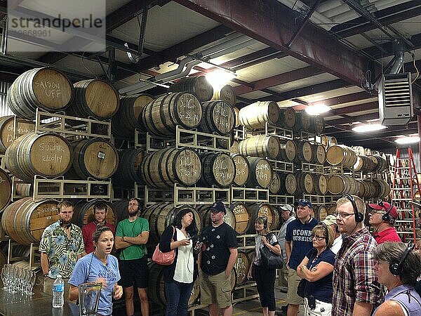 People on tour in room with casks of beer at Allagash Brewery