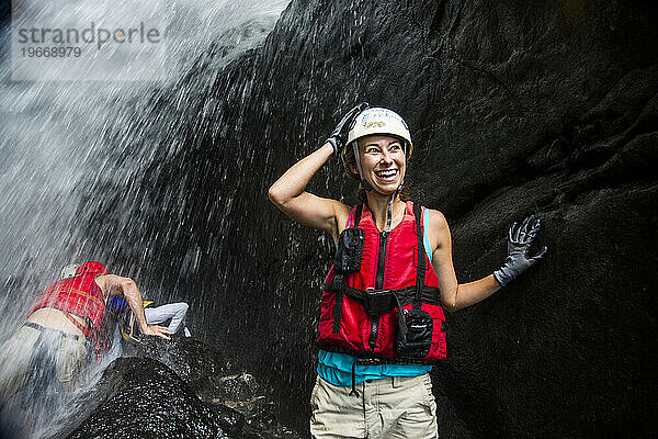 Eine Frau genießt mit anderen Touristen ein Wasserfallabenteuer in Puerto Rico.