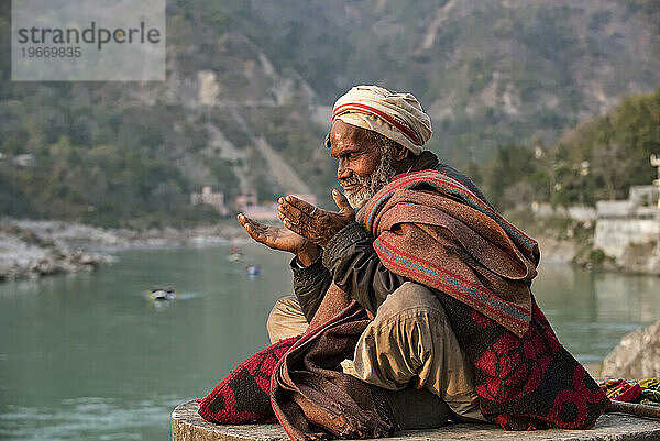 Ein älterer Mann meditiert am Ufer des Ganges in Rishikesh  Uttarakhand  Indien